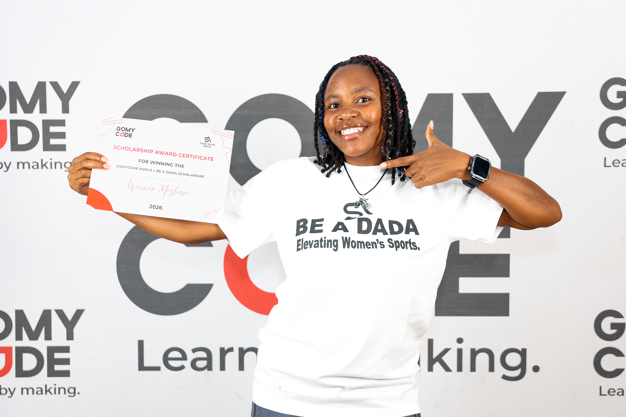 Kenyan cyclist Winnie Mashan posing with her tech scholarship certificate.